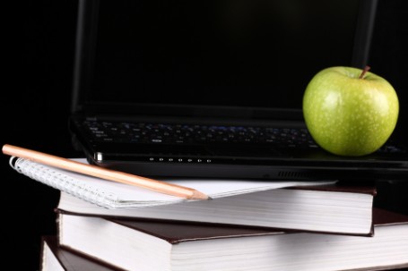 Computer, books, pencil, and apple